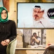 Two women in chairs converse front of screen that shows Jamal Khashoggi