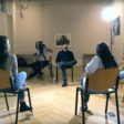 A group of people sitting in a circle are filmed