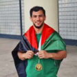 The Palestinian flag is draped around the shoulders of a smiling man 