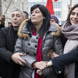 A woman is flanked by a man and a woman