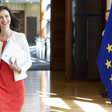 Woman smiles as she carries a dossier 