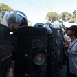 Protesters stand beside police in full riot gear 