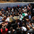 Crowd carries a body wrapped in an Islamic Jihad flag