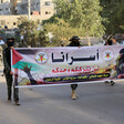 Men dressed in military uniform hold banner 