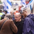 Three men at a demonstration with Israeli flags