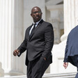 Two men in suits with their backs towards one another