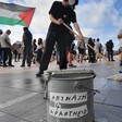 A protester mops the ground next to a bucket that says Artwash 4 Apartheid