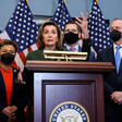 Members of Congress stand at podium