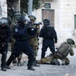 Heavily armed forces take position at a street corner 