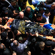 Man carry the body of a man on a stretcher 