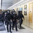 Men in right gear walk through hospital corridor