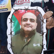 Close-up of hand holding poster of Mohammed El Halabi's portrait