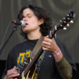 Woman plays the guitar and sings on a microphone 