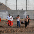 People including medics run away from Israeli army position while carrying person on stretcher