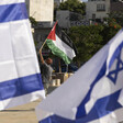 Person holds Palestine flag among group of Israeli flags