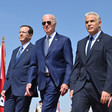 Joe Biden, wearing sunglasses, walks with Isaac Herzog to his right and Yair Lapid to his left