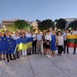 A group of people holds flags of EU and Ukraine and other countries