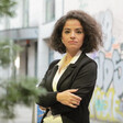 A woman stands with arms folded