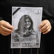 Close-up of two hands holding a black and white poster of Shireen Abu Akleh