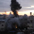A plume of smoke rises from an explosion between two low-rise building