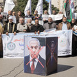 People hold signs, flags and banners and display images of Israeli officials with their faces crossed out