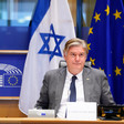 Member of the European Parliament Antonio López-Istúriz sits at a desk with the Israeli and European Union flags behind him