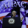 Joe Biden speaks before screen showing AIPAC's name and American and Israeli flags