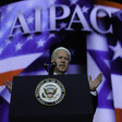 Joe Biden speaks before screen showing AIPAC's name and American and Israeli flags