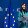 Mariya Gabriel stands at a podium with a large EU flag beside her