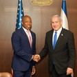 New York City Mayor Eric Adams shakes hands with Israeli Prime Minister Benjamin Netanyahu with American and Israeli flags behind them