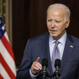 President Joe Biden stands at presidential podium with a US flag next to him