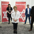 Five people standing in front of Jewish Labour Movement banners