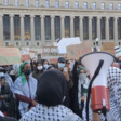 Students wearing traditional Palestinian scarves and holding signs and bullhorns protest on Columbia University's campus