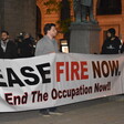 People stand with a banner calling for a ceasefire