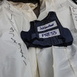 A press vest is laid atop two body bags 