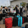 People with suitcases stand at the Rafah crossing 