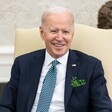 US President Joe Biden smiles as he wears shamrock in his jacket pocket 