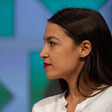 Side profile of a woman with long black hair and a white shirt 