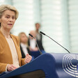 European Commission President Ursula von der Leyen stands at a podium with a microphone in front of her 