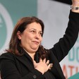 Palestinian Authority representative Jilan Wahba Abdalmajid waves in front of a green and white backdrop showing the letters SF 