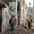 Girl and woman stand near the debris of destroyed infrastructure