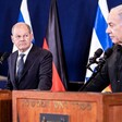 German Chancellor Olaf Scholz stands on a podium beside Israeli Prime Minister Benjamin Netanyahu