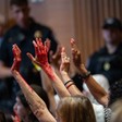 Protesters with hands painted red in Senate Appropriations Committee hearing