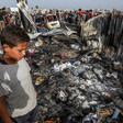 A boy looks down at charred personal belongings