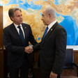 Secretary of State Antony Blinken shakes hands with Israeli Prime Minister Benjamin Netanyahu with a map behind them