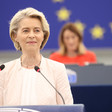 European Commission President Ursula von der Leyen stands at a podium with two microphones 