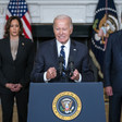 President Joe Biden speaks in the State Dining Room of the White House with Vice President Kamala Harris and Secretary of State Tony Blinken behind him