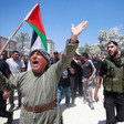 Palestinians carry weapons, flag during a funeral march 