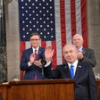 Benjamin Netanyahu stands in front of Mike Johnson, Ben Cardin and American flag