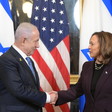 US Vice President Kamala Harris shakes hands with Israeli Prime Minister Benjamin Netanyahu with an American flag and two Israeli flags behind them